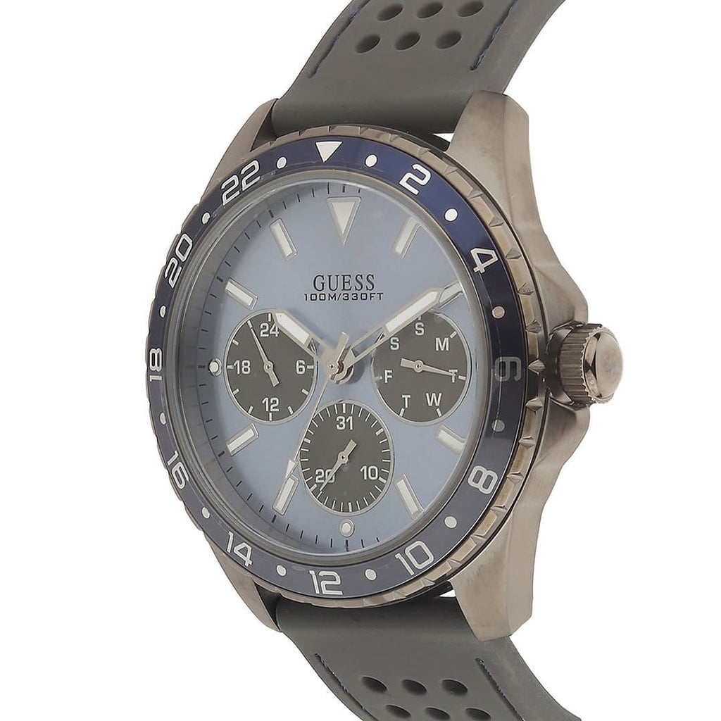 ساعة Guess Odyssey W1108G6 بهيكل بلون رصاصي داكن، ومينا أزرق سماوي، وحزام مطاطي رمادي