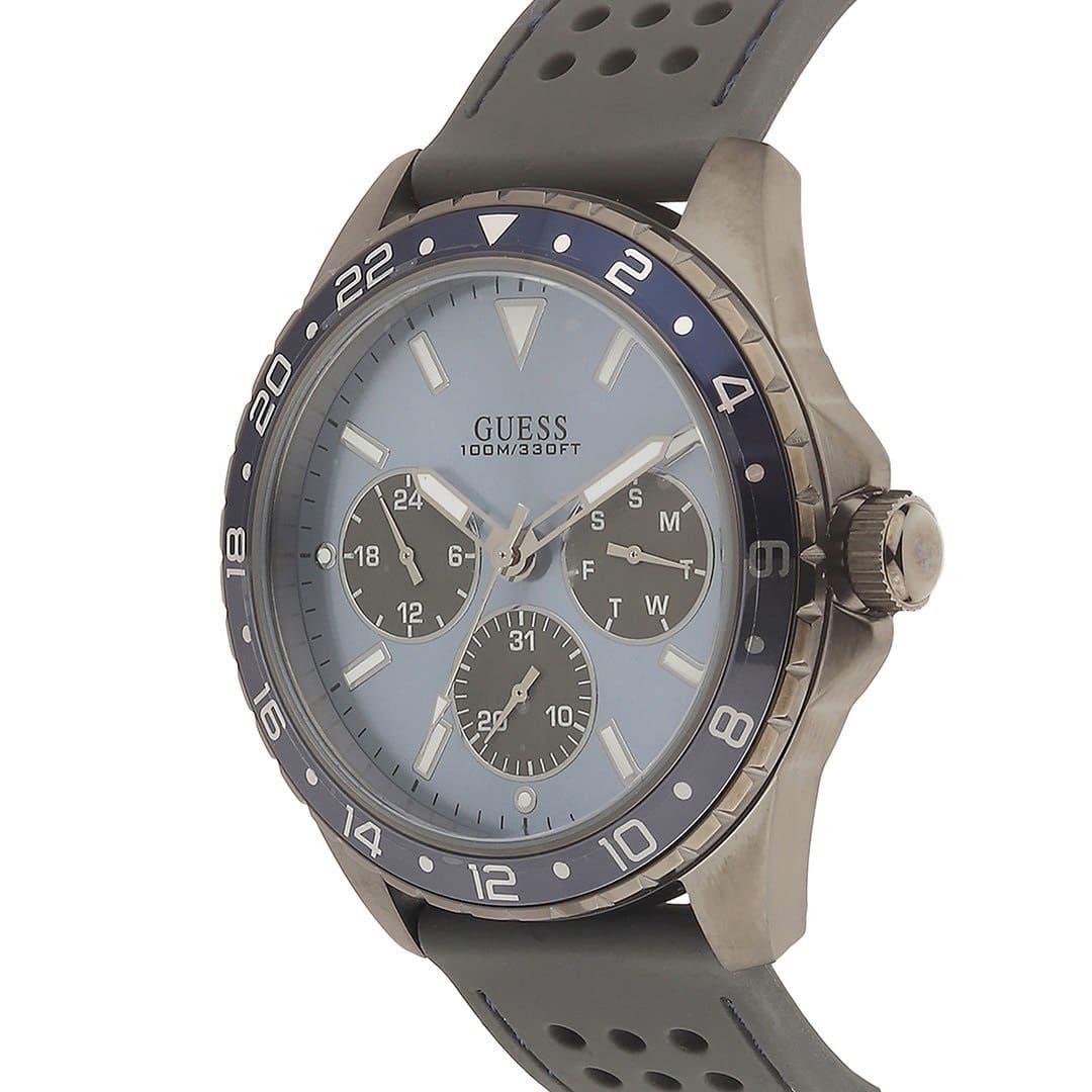 ساعة Guess Odyssey W1108G6 بهيكل بلون رصاصي داكن، ومينا أزرق سماوي، وحزام مطاطي رمادي