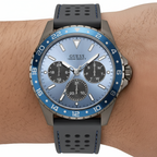 ساعة Guess Odyssey W1108G6 بهيكل بلون رصاصي داكن، ومينا أزرق سماوي، وحزام مطاطي رمادي