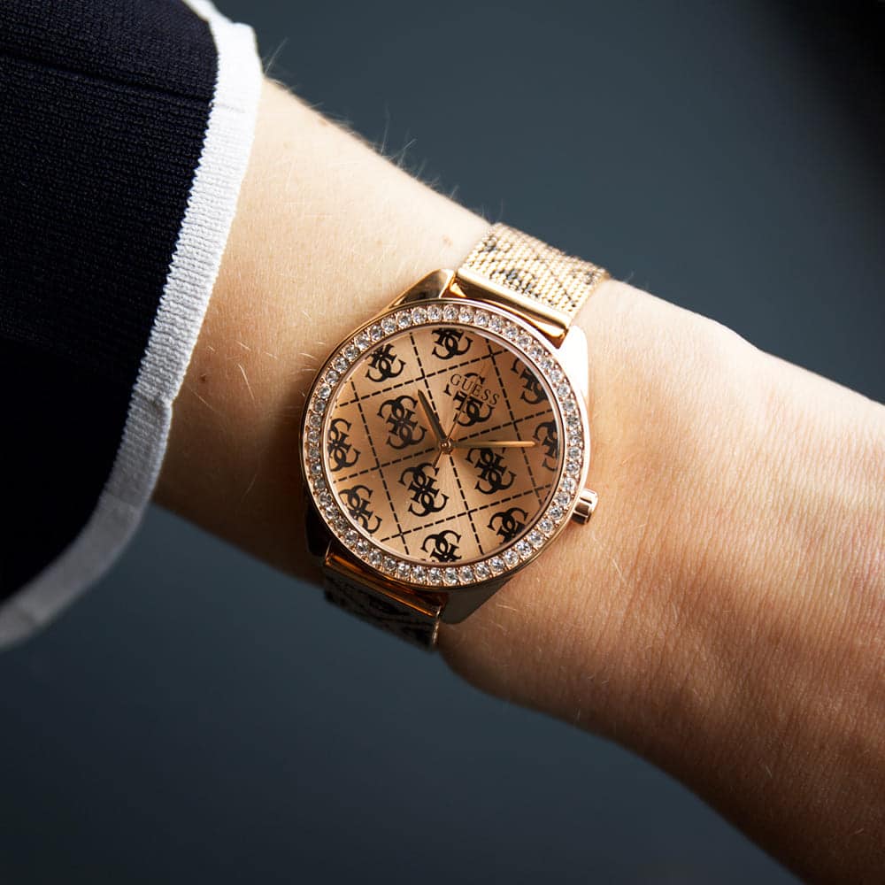 ساعة Guess Claudia W1279L3 نسائية بلون ذهبي وردي بحركة كوارتز، إطار مرصع بالكريستال وشعار 4G، سوار شبكي ذهبي وردي